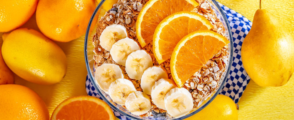 Bowl of cereal with bananas and oranges for Breakfast on fresh f